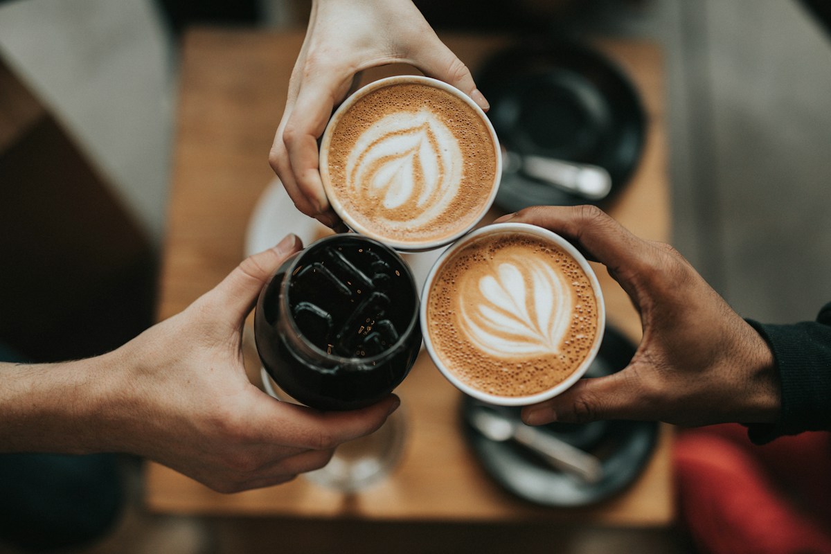 Friends holding their coffee cups together